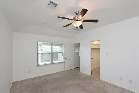 an empty room with windows and fan