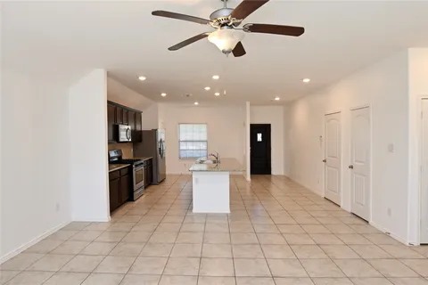 a kitchen with stainless steel appliances kitchen island granite countertop a refrigerator and a sink