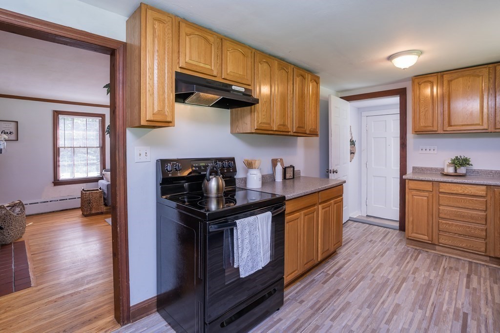 152 Feeding Hills Road Southwick, MA 01077 - Photo 4 of 35 a kitchen with stainless steel appliances granite countertop wooden floors a stove and a microwave