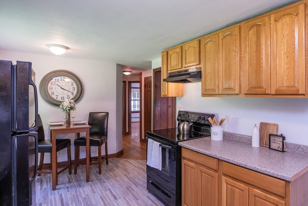 152 Feeding Hills Road Southwick, MA 01077 - Photo 6 of 35 a kitchen with a table chairs refrigerator and cabinets