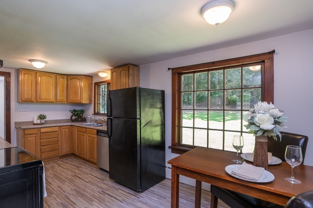 152 Feeding Hills Road Southwick, MA 01077 - Photo 7 of 35 a kitchen with stainless steel appliances granite countertop a stove a refrigerator a sink dishwasher a dining table and chairs with wooden floor