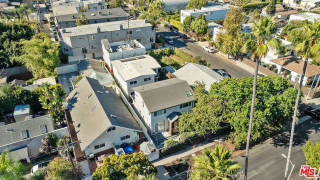 an aerial view of a residential apartment building with a yard and parking spaces