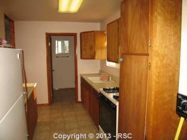 1450 Buck Road Calhan, CO 80808 - Photo 12 of 25 This is the kitchen in the guest home. There is an exit door by the kitchen. There is also a bathroom with a shower too. Remember the refrigerator, washer and dryer for the guest home is included too. All are included as-is.