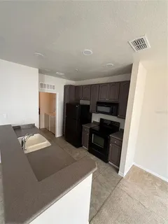 a kitchen with granite countertop a refrigerator and a stove
