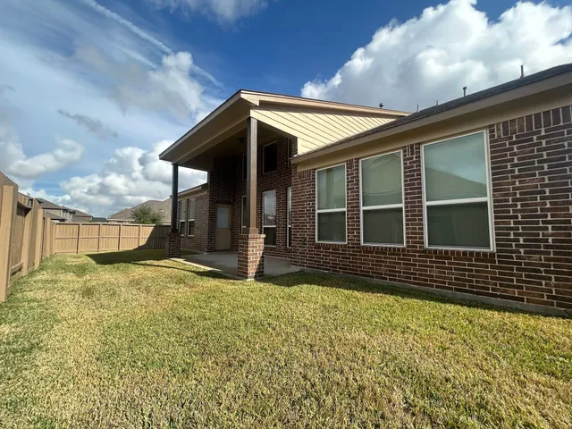 a view of house with backyard and balcony