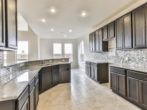 a large kitchen with stainless steel appliances granite countertop a sink stove and cabinets