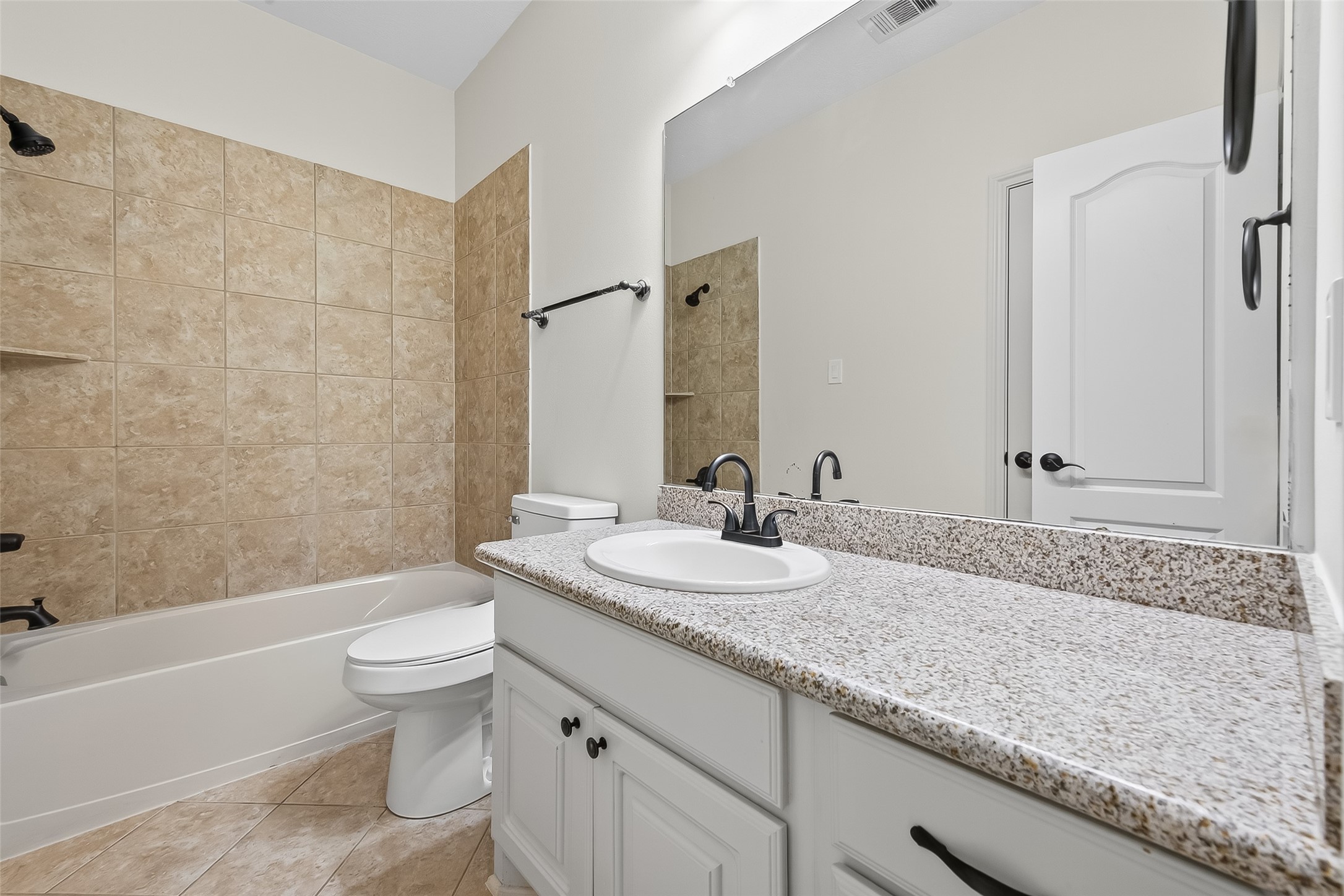 5815 Mustang Ridge Lane Fulshear, TX 77441 - Photo 32 of 50 a bathroom with a granite countertop sink a toilet and bathtub