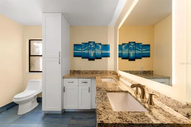 a bathroom with a granite countertop sink and a mirror