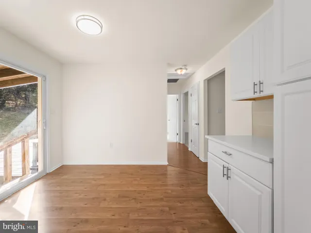 a view of a kitchen with wooden floor and electronic appliances
