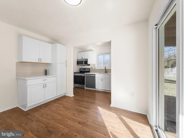 a kitchen with white cabinets and white appliances