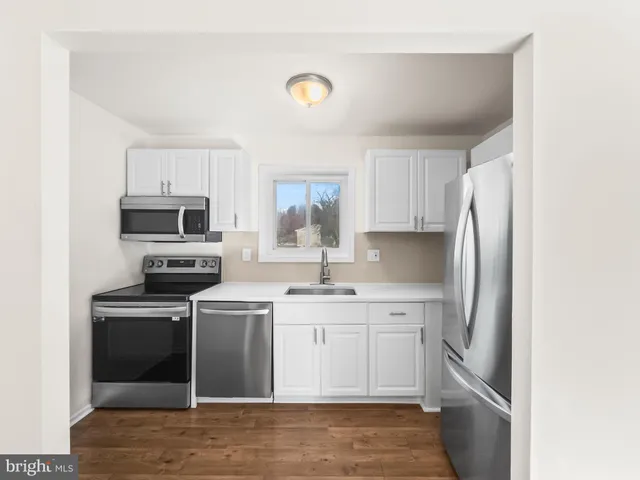 a kitchen with a sink a stove a refrigerator and cabinets