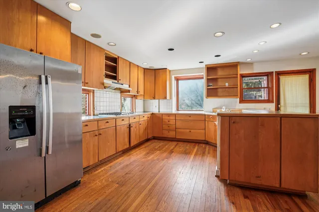 a kitchen with stainless steel appliances wooden floors and wooden cabinets