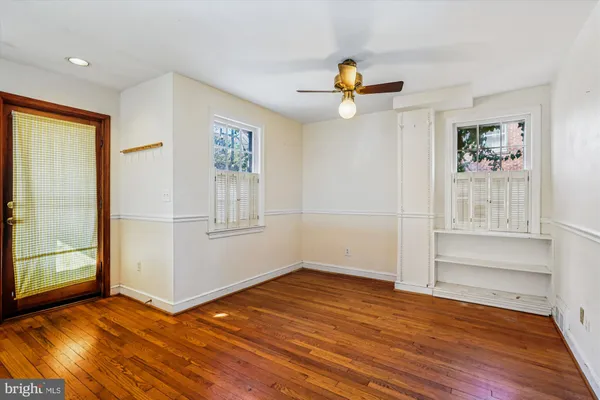 an empty room with wooden floor and window