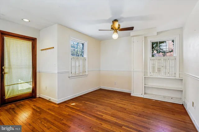 an empty room with wooden floor and window