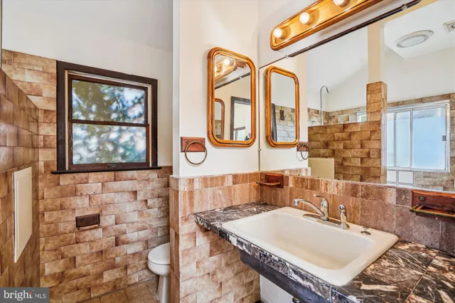 a bathroom with a sink a mirror a vanity and a shower