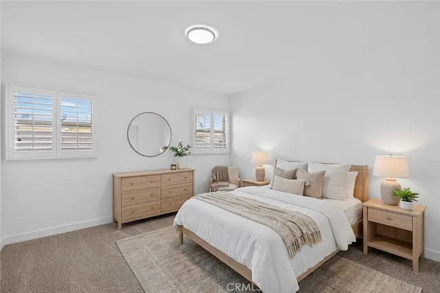 a bedroom with a bed a mirror and a window