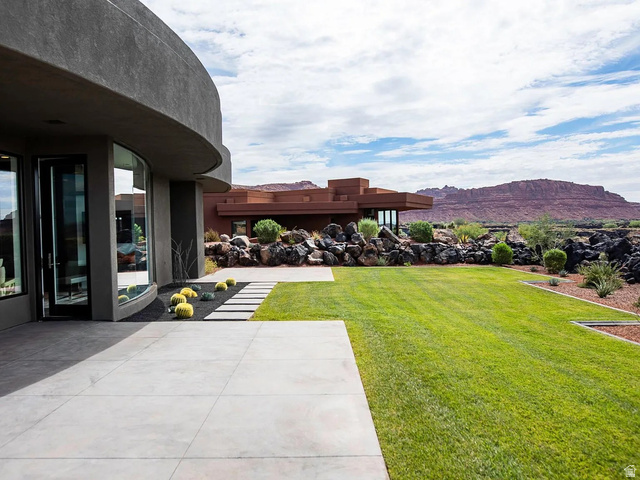 1500 Split Rock, Unit 150 Ivins, UT 84738 - Photo 2 of 14 Expansive exterior patio featuring large format concrete pavers, a manicured lawn, and natural stone landscaping