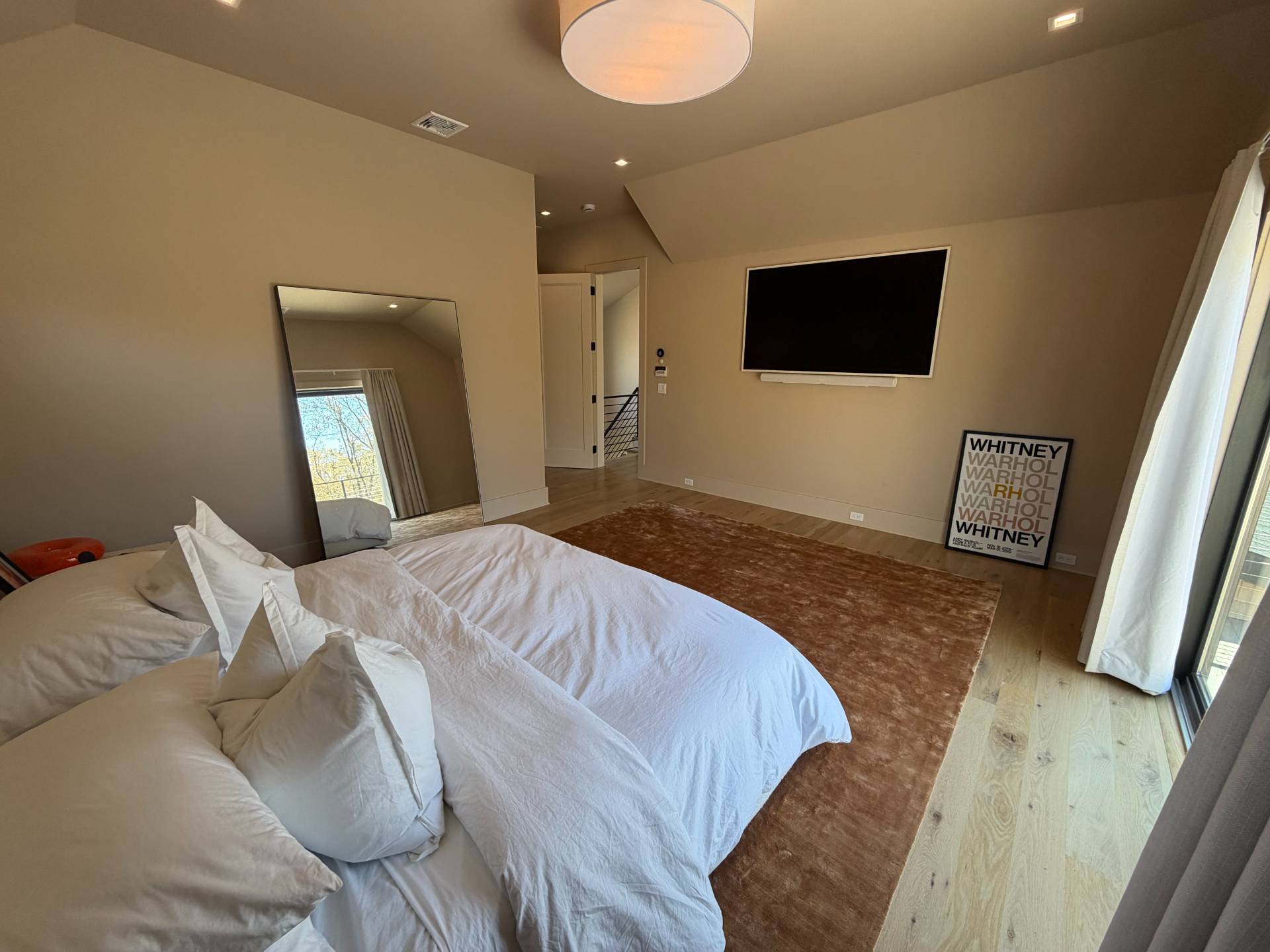62 Whooping Hollow Road East Hampton, NY 11937 - Photo 12 of 31 a bedroom with a bed and a flat screen tv