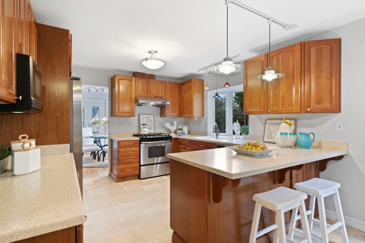 155 Belhaven Drive Los Gatos, CA 95032 - Photo 11 of 30 a kitchen with a sink a stove a kitchen island with chairs and wooden cabinets