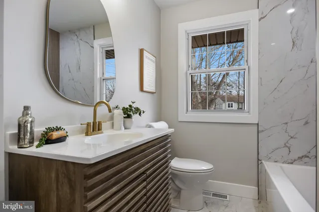 a bathroom with a sink a toilet and a mirror