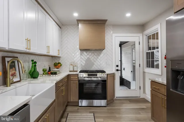 a kitchen with stainless steel appliances granite countertop a stove a sink and a refrigerator