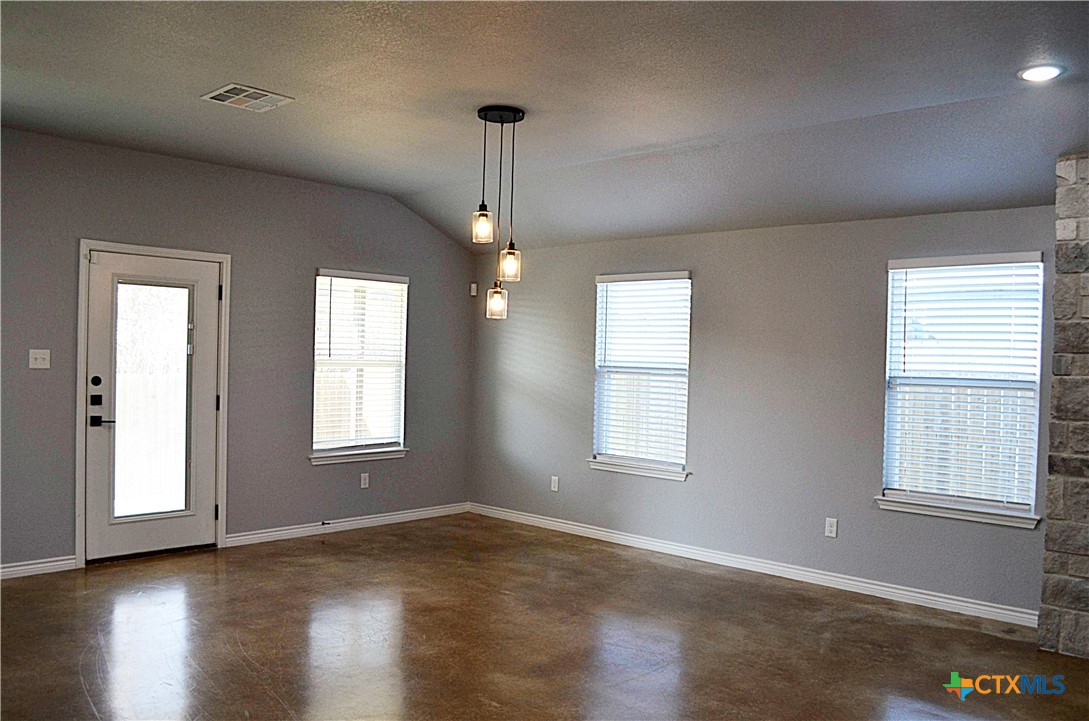 745 Freedom Circle Nolanville, TX 76559 - Photo 11 of 38 a view of an empty room with wooden floor and a window