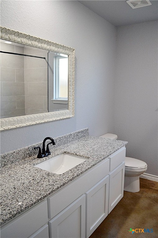 745 Freedom Circle Nolanville, TX 76559 - Photo 26 of 38 a bathroom with a granite countertop sink a toilet and a mirror