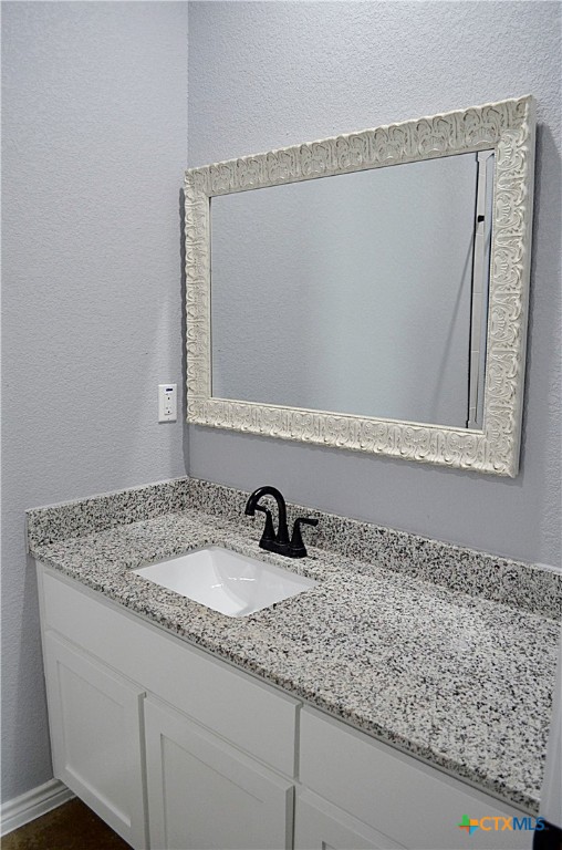745 Freedom Circle Nolanville, TX 76559 - Photo 35 of 38 a bathroom with a granite countertop sink and a mirror