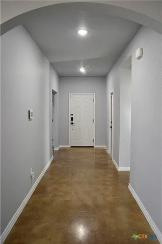 an empty room with windows and fireplace