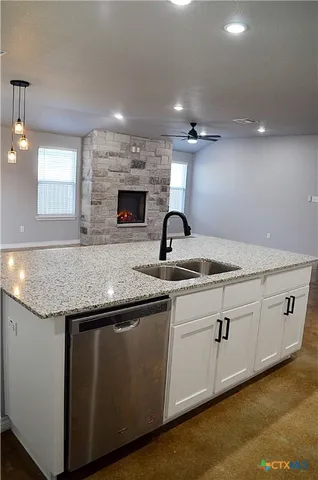 a kitchen with granite countertop a stove and a sink