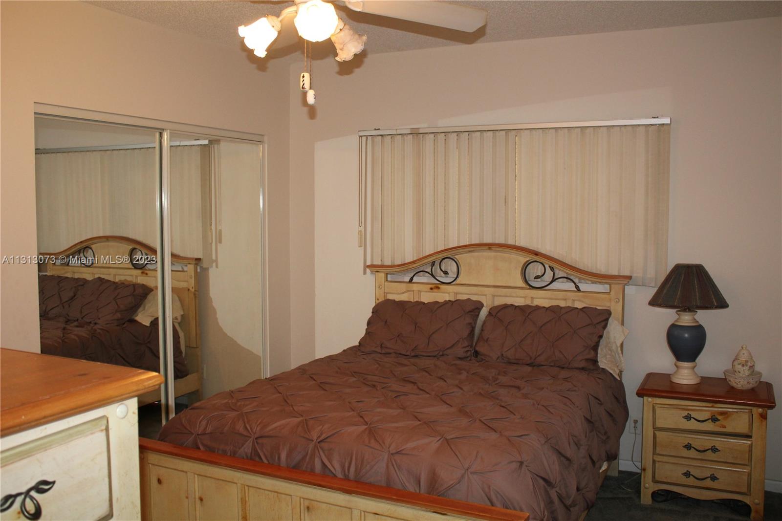 4730 Southwest 62nd Way, Unit 301 Davie, FL 33314 - Photo 11 of 33 a bedroom with a bed and a mirror
