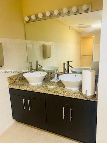 4730 Southwest 62nd Way, Unit 301 Davie, FL 33314 - Photo 29 of 33 a bathroom with a granite countertop sink and a mirror