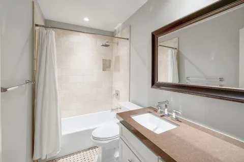 a bathroom with a granite countertop sink toilet and shower