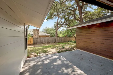 a view of backyard with wooden fence
