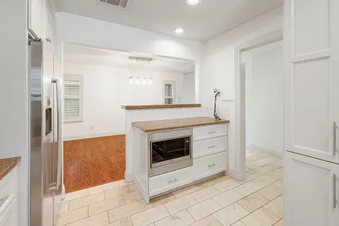 a kitchen with white cabinets and white appliances