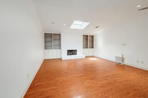 an empty room with fireplace and windows