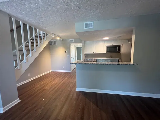 a view of kitchen with wooden floor and electronic appliances