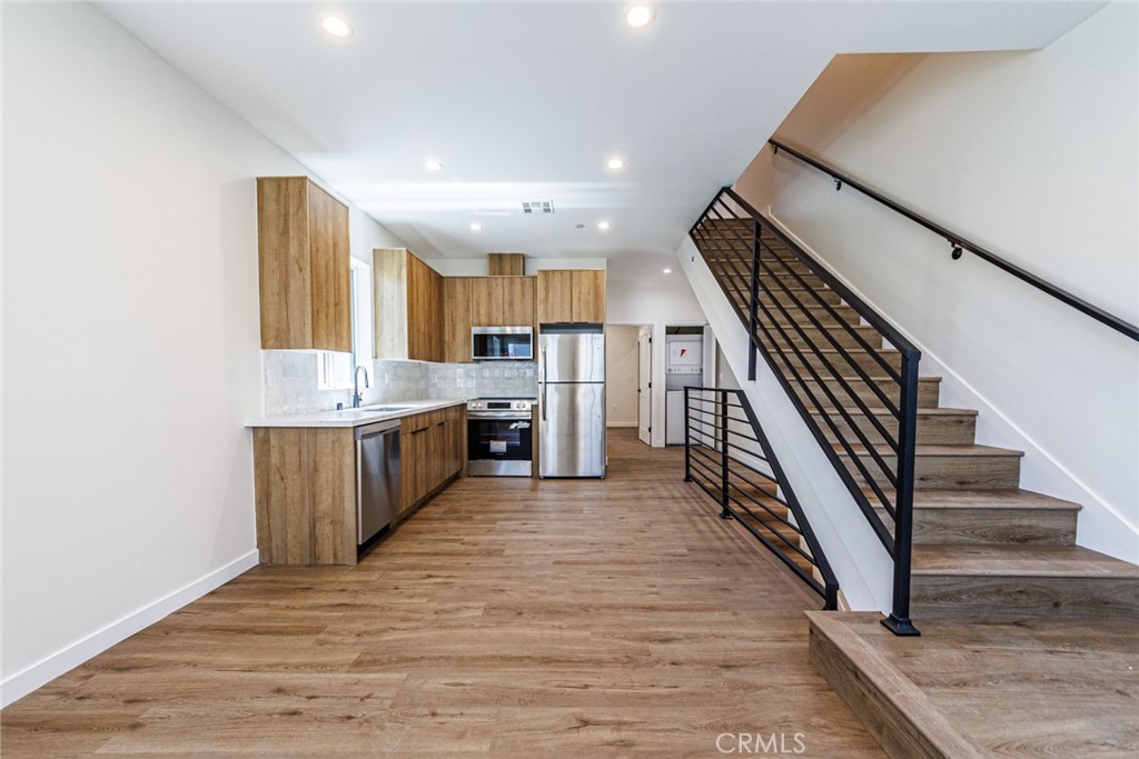 1857 Crenshaw Boulevard, Unit 1/2 Los Angeles, CA 90019 - Photo 11 of 24 a large kitchen with cabinets wooden floor and stainless steel appliances