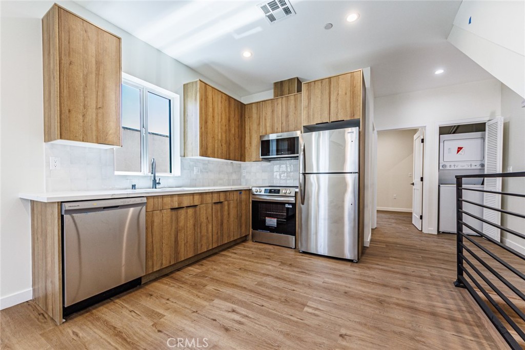 1857 Crenshaw Boulevard, Unit 1/2 Los Angeles, CA 90019 - Photo 12 of 24 a kitchen with a refrigerator a sink and dishwasher a oven with wooden floor