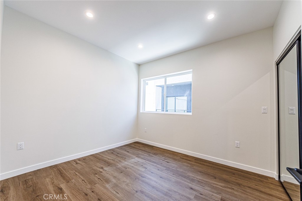 1857 Crenshaw Boulevard, Unit 1/2 Los Angeles, CA 90019 - Photo 14 of 24 an empty room with wooden floor and windows