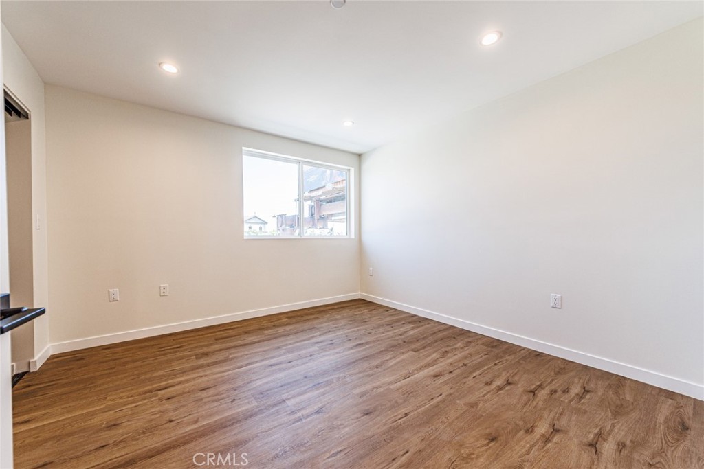 1857 Crenshaw Boulevard, Unit 1/2 Los Angeles, CA 90019 - Photo 18 of 24 an empty room with wooden floor and windows