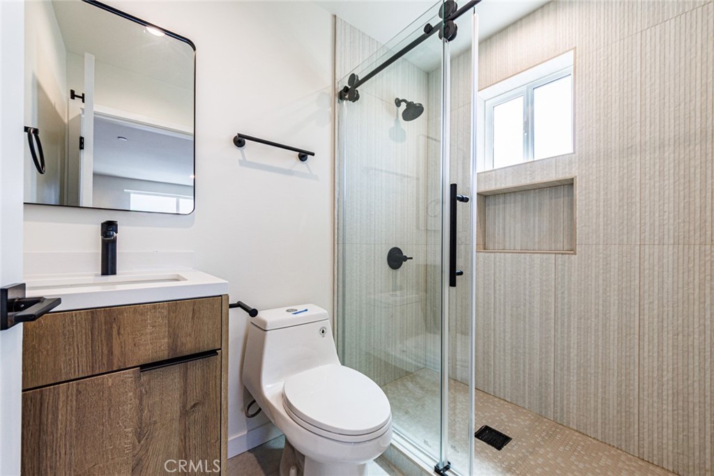 1857 Crenshaw Boulevard, Unit 1/2 Los Angeles, CA 90019 - Photo 24 of 24 a bathroom with a toilet a sink and a mirror
