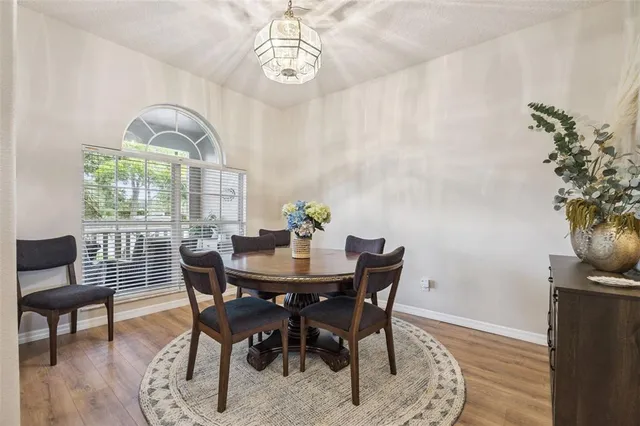 a dining room with wooden floor and chandelier