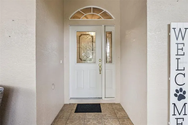 a view of a hallway with wooden door and windows