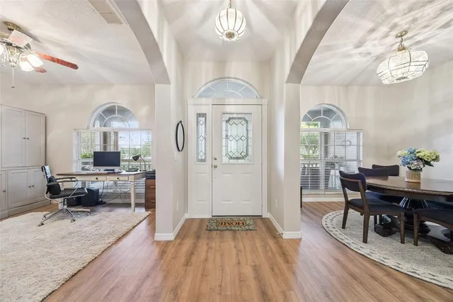 a view of a hallway with wooden floor and furniture