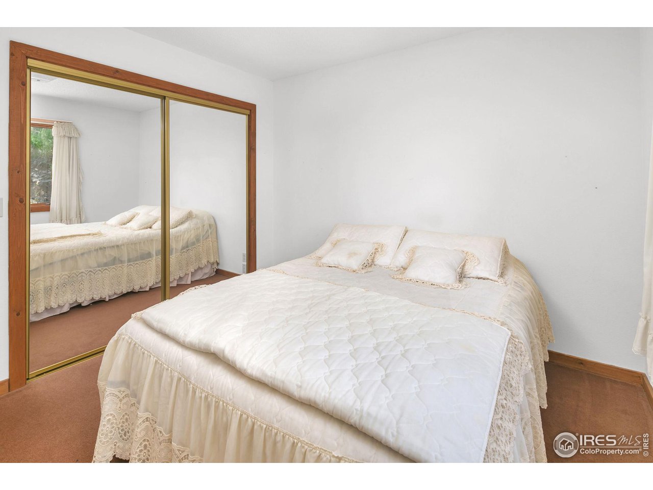 1052 Streamside Drive Drake, CO 80515 - Photo 14 of 31 a bedroom with a large bed and a large mirror