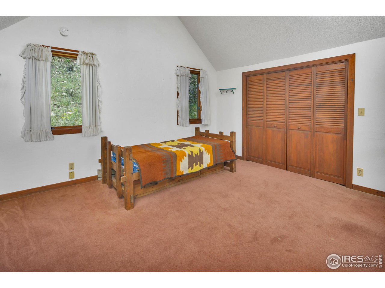 1052 Streamside Drive Drake, CO 80515 - Photo 18 of 31 a spacious bedroom with a bed and a window