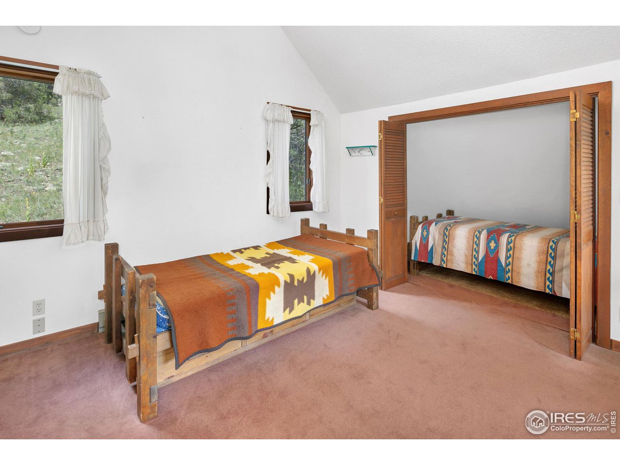 1052 Streamside Drive Drake, CO 80515 - Photo 19 of 31 a spacious bedroom with a bed and a dresser