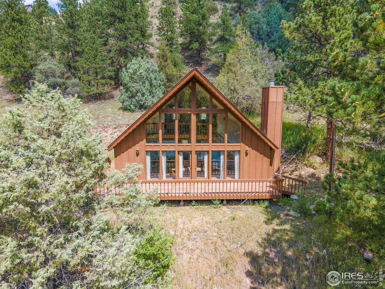 1052 Streamside Drive Drake, CO 80515 - Photo 2 of 31 a view of a house with a yard and large trees