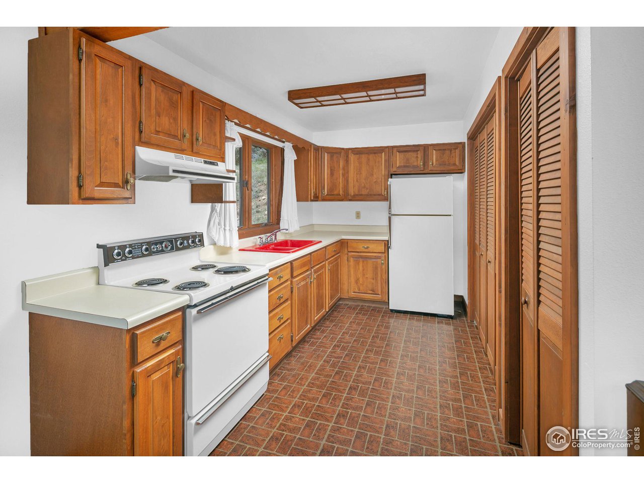 1052 Streamside Drive Drake, CO 80515 - Photo 8 of 31 a kitchen with a sink stove and cabinets
